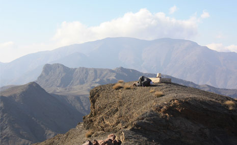 A man praying with the Atlas Mountains in the background